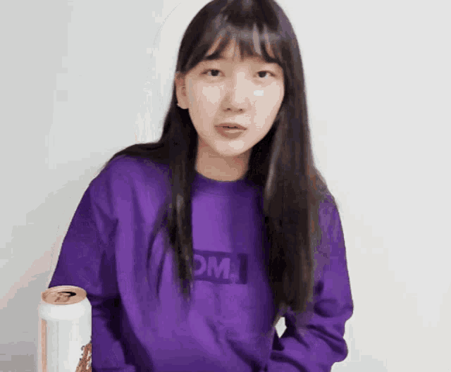 a girl wearing a purple sweater with the word om on it