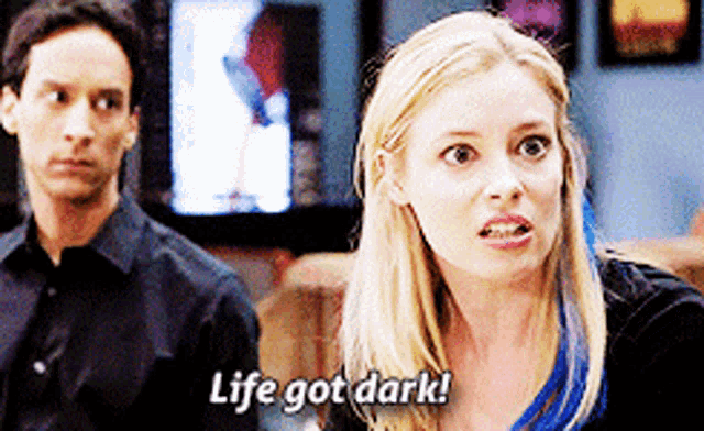 a woman says life got dark while a man stands behind her