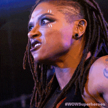 a woman with dreadlocks has a #wowsuperheroes sticker on her arm