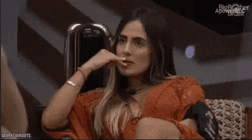 a woman is sitting in a chair with her hand in her mouth