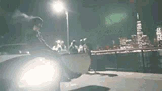 a man is riding a skateboard on a ramp at night .