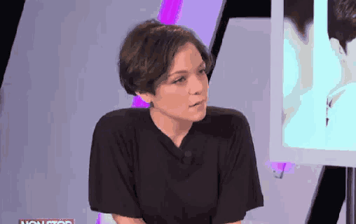 a woman in a black shirt talks on a television show called non stop