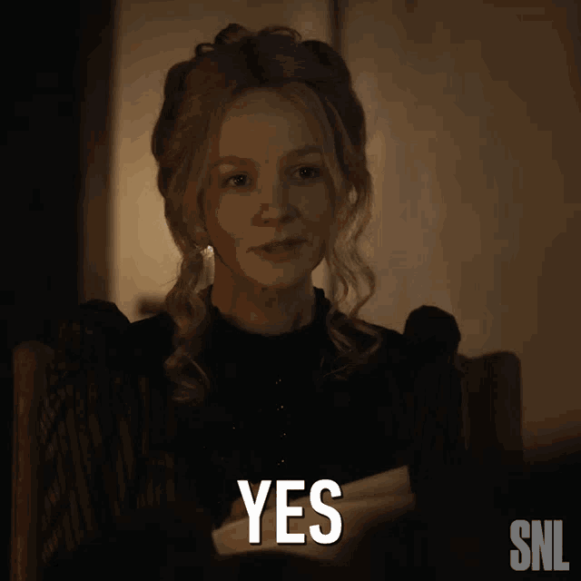 a woman sitting in a chair with a snl logo next to her
