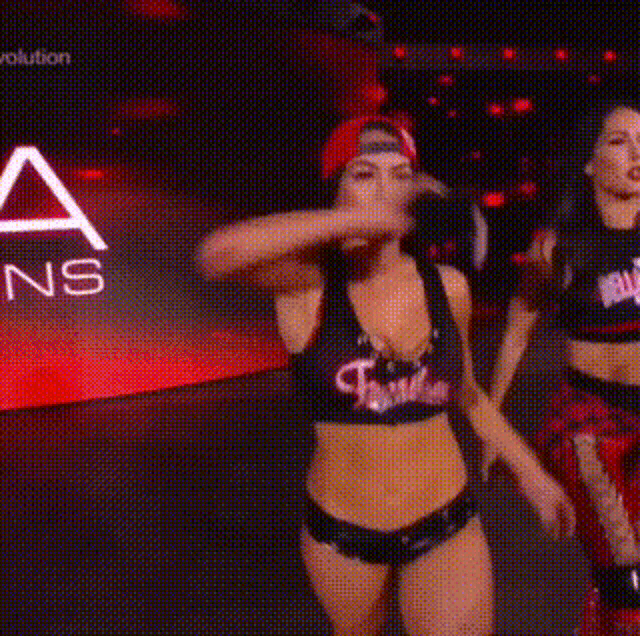 a couple of women are standing next to each other in front of a sign that says `` twins '' .