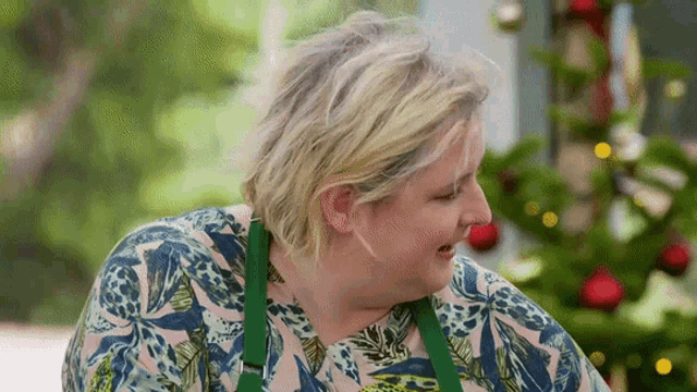 a woman with blonde hair wearing a green apron