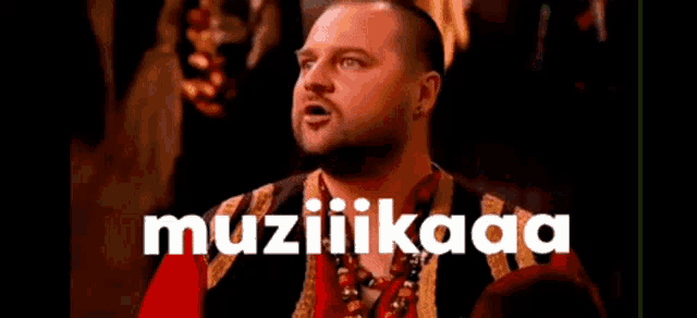 a man with a bandage on his head is sitting at a table with the word muzicaa written on the bottom