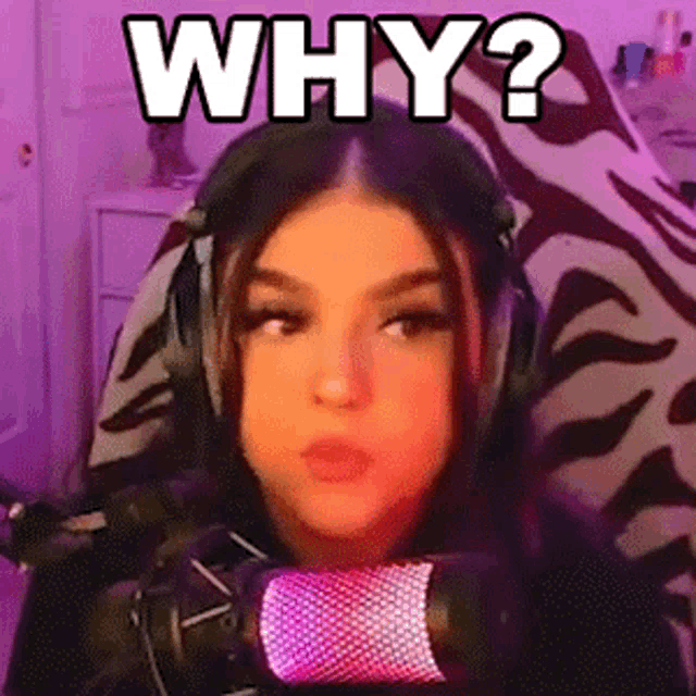 a woman wearing headphones is sitting in front of a microphone and making a funny face .