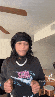 a man with long hair and dreadlocks is wearing a black nike shirt and a black headband .