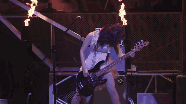 a woman playing a guitar in front of a keyboard that says yamaha on the front