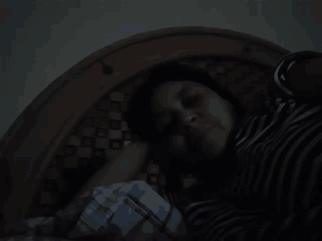 a woman in a striped shirt is laying on a bed