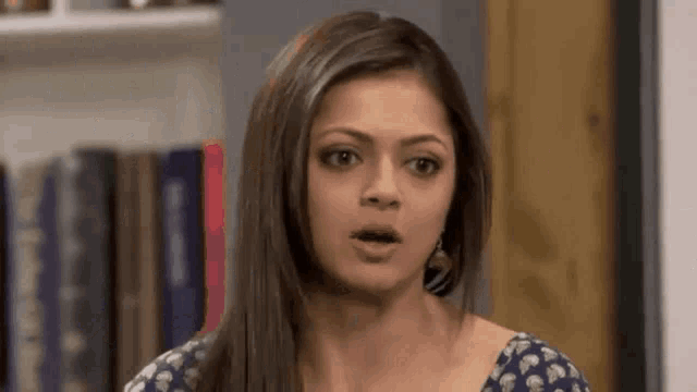 a woman with long hair is making a surprised face .