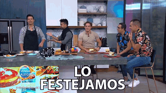 a group of men sitting at a table with a sign that says lo festejamos on it