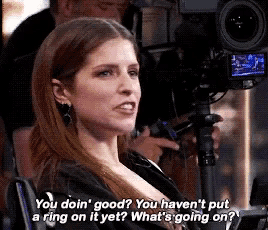 a woman is sitting in front of a camera with the words " you doin ' good " on the bottom