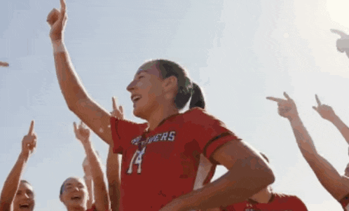 a female soccer player wearing a red shirt with the number 14 on it