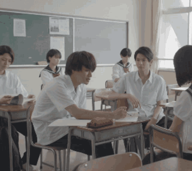 a group of students sitting at desks in a classroom