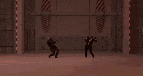 a couple of people standing in front of a large explosion .