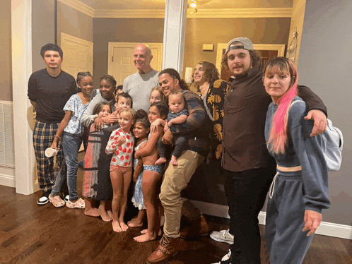 a group of people posing for a picture including a woman with pink hair