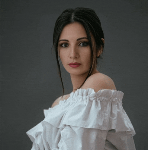 the woman is wearing a white off the shoulder top