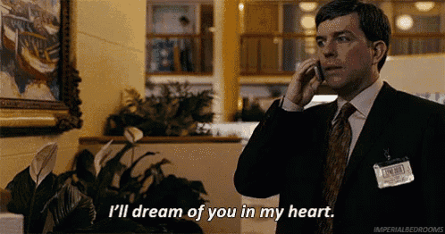 a man in a suit and tie is talking on a cell phone while saying i 'll dream of you in my heart .