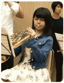 a girl is playing a trumpet in a band