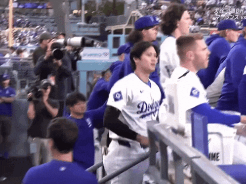 a man in a dodgers jersey stands in a dugout
