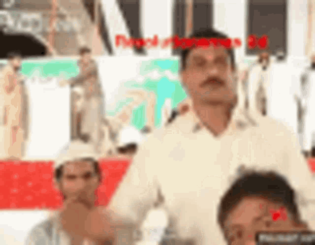 a man in a white shirt is standing in front of a crowd of people .