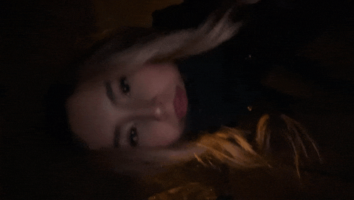 a close up of a woman 's face in the dark with her eyes closed .