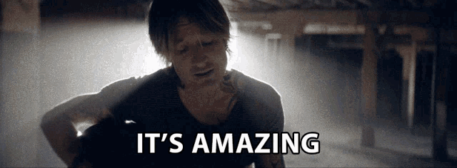a man playing a guitar with the words " it 's amazing " written below him