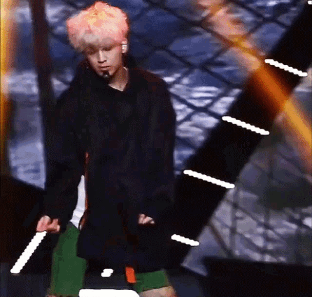 a young man with blonde hair is standing on a stage .