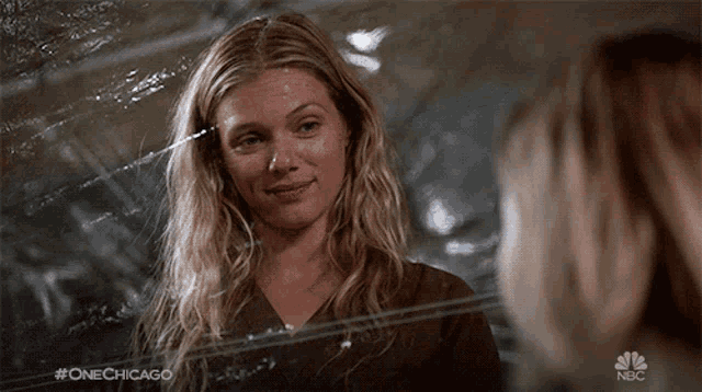 a woman is looking at herself in a mirror with #onechicago on the bottom