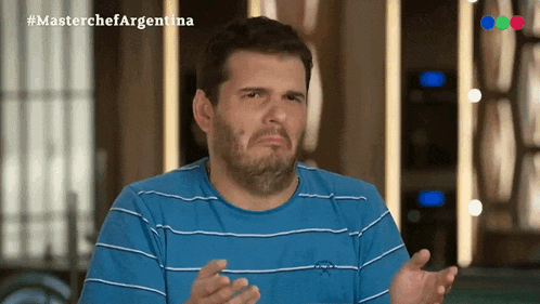 a man with a beard wearing a blue and white striped shirt with the hashtag #masterchefargentina