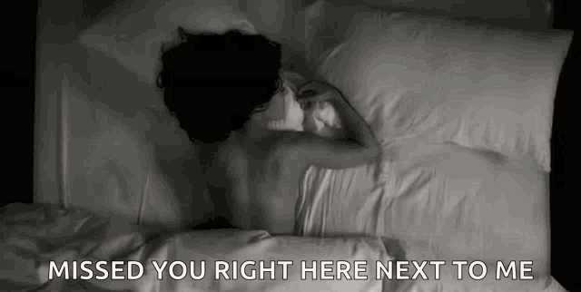 a woman is laying in bed with the words `` missed you right here next to me '' .
