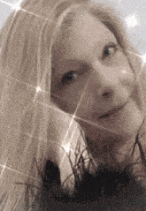 a close up of a woman 's face with sparks coming out of her hair