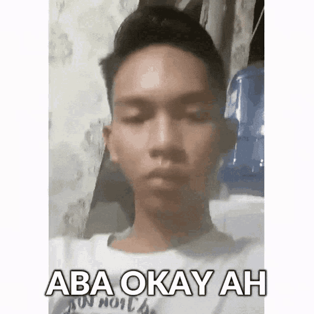 a young man is wearing a white shirt with the words aba okay ah on it