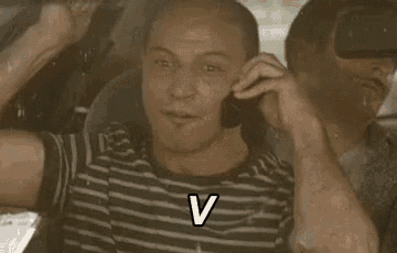 a man is talking on a cell phone in a car while another man watches .