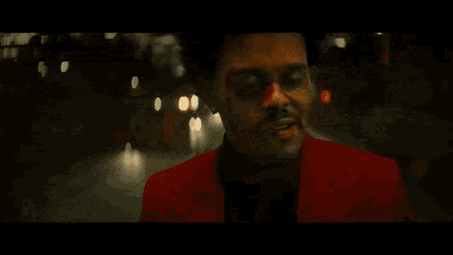 a man in a red suit is smiling with a black eye