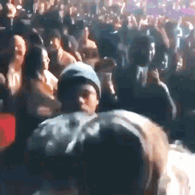 a crowd of people at a concert with a man wearing a beanie that says ' n ' on it