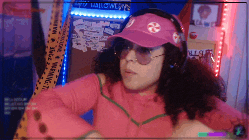 a woman wearing a pink hat with a candy cane on it and headphones