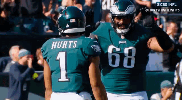 a football player with the number 1 on his jersey is talking to another player