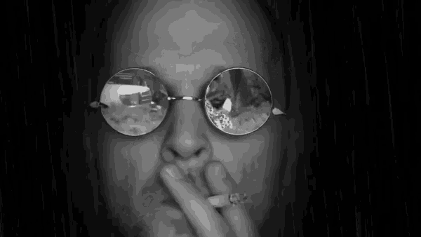 a black and white photo of a man wearing glasses