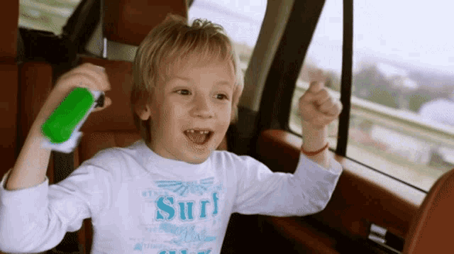a young boy wearing a white shirt that says surf