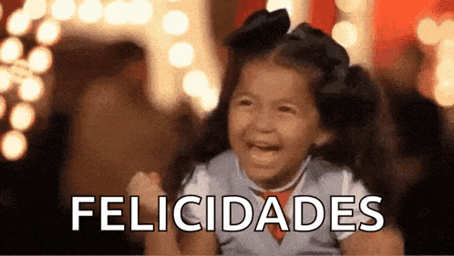 a little girl is smiling and holding her fist up in the air with the word felicidades behind her