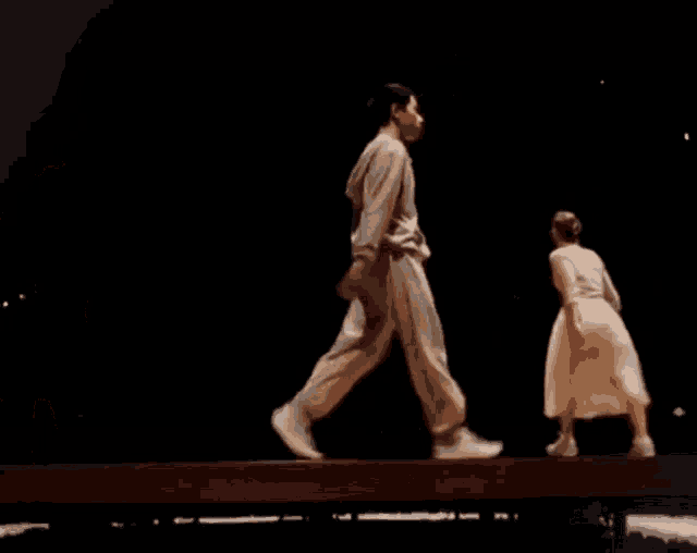 a man and a woman are dancing on a stage .
