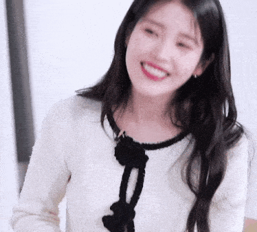 a close up of a woman wearing a white and black sweater smiling .