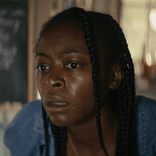 a close up of a woman 's face with braids on it