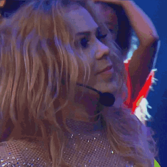a close up of a woman wearing a microphone and a neon yellow dress