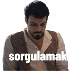a man with a beard is wearing a vest and a white shirt and has the word sorgulamak written on his chest .