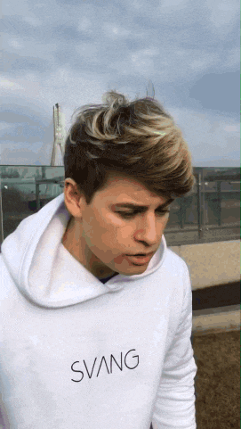 a young man wearing a white sweatshirt with the word svang on the front