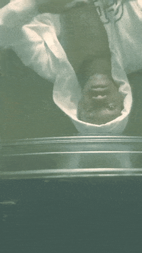 a man in a white shirt is upside down on a table