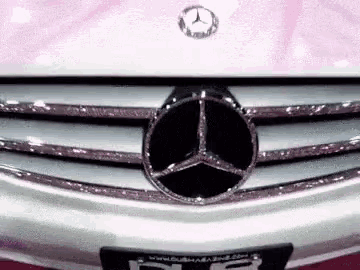 a close up of a mercedes benz car with rhinestones on it 's grille .